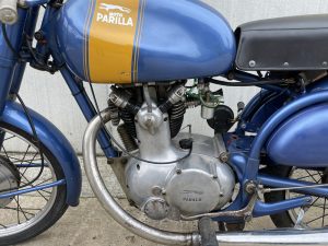 a close up of a blue 020 parilla 175 sport 03 motorcycle